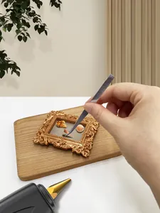 DIY process of placing sea shells into a vintage golden baroque embossed frame