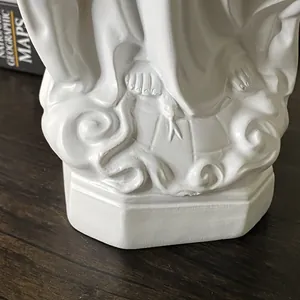 Dettaglio macro della base di statua religiosa in resina con piedi che calpestano serpente