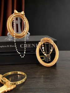 Detailed view of vintage gold jewelry set with pearl necklace and embossed eye bracelet