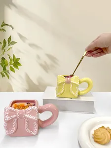 Dettaglio di tazze in ceramica rosa e gialle con rilievo a fiocco e bordo a onde