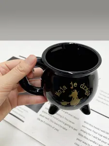 Makroaufnahme der schwarzen Hexenkessel-Tasse aus Keramik mit goldenem Silhouette-Motiv