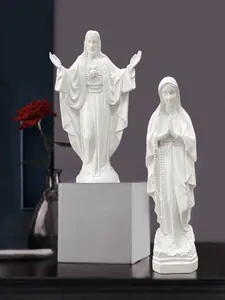 Dettaglio di figure religiose in resina bianca con Sacro Cuore e dettagli del rosario