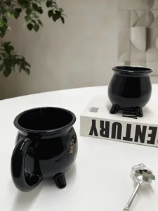 Detailansicht der schwarzen Hexenkessel-Tasse aus Keramik mit goldener Moja-Schrift