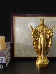 Dettaglio di una statua dorata del Sacro Cuore di Gesù con base ottagonale su scrivania