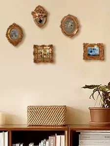 Detail of five vintage baroque gold frames featuring floral and butterfly art inserts
