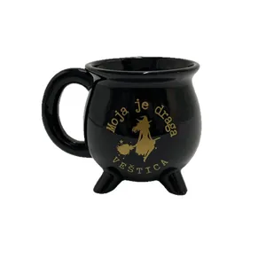 Schwarze Keramiktasse in Hexenkessel-Form mit goldenem Hexen- und Sterndesign