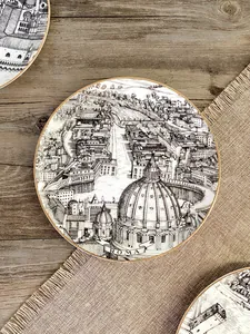 Dettaglio del piatto in ceramica con schizzo dell'architettura di Roma e bordo dorato