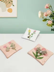 Macro di tappetini per gioielli in ecopelle con motivi floreali di tulipani e rose