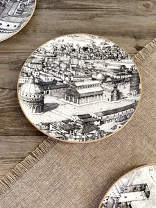 Dettaglio del piatto in ceramica con schizzo in bianco e nero di Pisa e bordo dorato