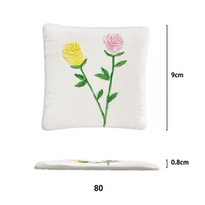 Vista dettagliata di sottobicchiere quadrato bianco 9cm con rilievi floreali a rosa