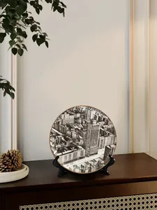 Dettaglio del piatto in ceramica Milano con arte architettonica e bordo dorato su supporto