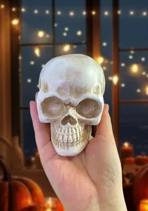 Detailed view of a resin skull head decor held in hand showing realistic bone textures