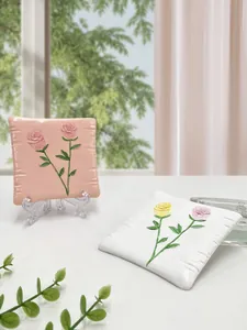 Dettaglio di sottobicchieri quadrati in resina con rose 3D per gioielli e decorazione