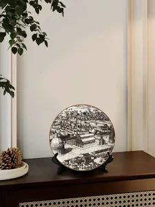 Dettaglio del piatto in ceramica PISA con schizzo della città e supporto da tavolo