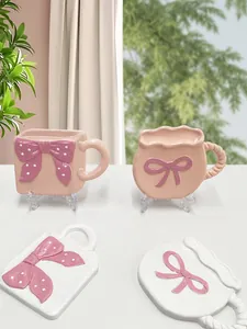Dettaglio dei sottobicchieri in ceramica rosa e bianca con fiocco decorativo e pois