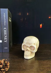 Detailed realistic resin skull sculpture with vintage finish on a dark wooden background