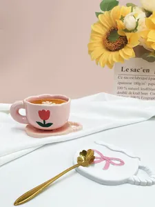 Dettaglio della tazza tulipano rosa con piattino ondulato e cucchiaio in oro