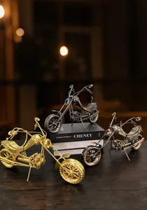 Drie vintage metalen motorfietsmodellen in goud, brons en zwart met industriële details