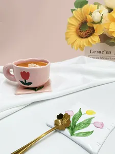 Dettaglio della tazza a tulipano con bordo ondulato, sottobicchiere e cucchiaio d'oro