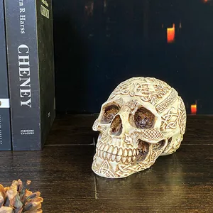 Nordic Halloween skull resin ornament with intricate geometric carvings on dark wood