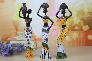 Detailed view of three resin African figurines carrying pots in vibrant ethnic attire