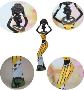 Detailed close-up of African resin figurines showing intricate giraffe prints and yellow dress