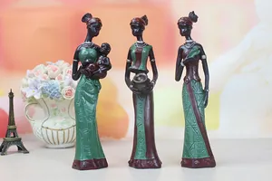 Detailed view of three African figurines with textured green dresses and tribal patterns