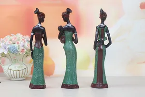 Detailed view of African resin figurines with intricate relief patterns and green dresses