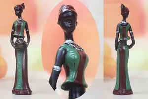 Detailed view of African resin figurine showing elegant dress patterns and ethnic jewelry