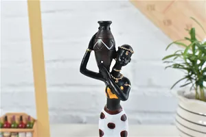 Detailed craftsmanship of an African resin figurine with gold jewelry and a hand-painted pot