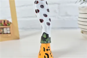 Close-up of African resin figurine detailing giraffe and cheetah animal prints