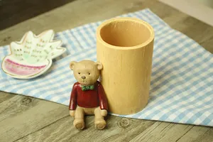 Close-up of a rustic wooden-style pencil holder with a cute 3D bear in red sweater