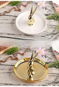 Close-up of gold and white ceramic rabbit jewelry trays for rings and small accessories