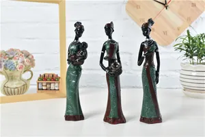 Close-up of three African resin figurines with detailed tribal patterns and textures