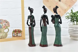 Detailed view of African resin figurines featuring green tribal dresses and hand-carved textures