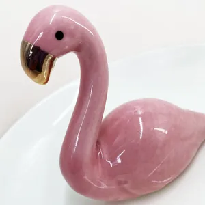 Macro shot of pink ceramic flamingo jewelry holder with elegant gold beak detailing