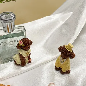 Close-up of resin poodle figurines in lace dress and yellow tuxedo for home decor