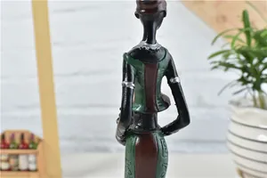 Detail view of African tribal resin figurine featuring embossed green ethnic patterns