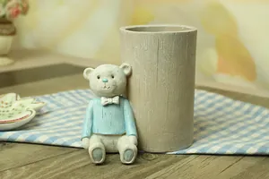 Detail view of cute bear pen holder on a blue checkered tablecloth with floral background