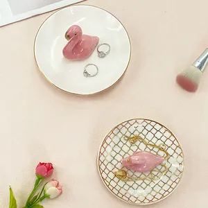 Detail of flamingo ceramic jewelry trays with gold diamond pattern and rings storage