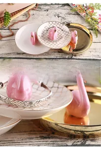 Detail of flamingo ceramic jewelry tray set showing pink figurine and gold-edged patterns
