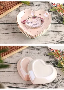 Detailed view of heart-shaped ceramic jewelry tray with gold edge and unicorn motif