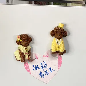 Close-up of resin poodle fridge magnets in wedding outfits on white surface