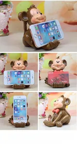 Detail of cute monkey resin phone stand showing front view and side profile on a desktop
