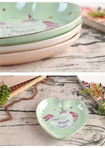 Detail of mint green heart ceramic jewelry dish with gold rim and unicorn design