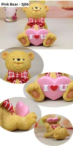 Macro detail of resin bear figurine holding a pink heart with I love you text