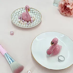 Detail of ceramic flamingo jewelry tray showing golden grid patterns and ring holder