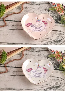 Detail of heart-shaped ceramic jewelry tray with unicorn design and gold trim