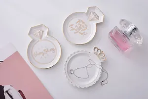 Ceramic jewelry tray featuring gold-rimmed ring shapes with elegant artistic text