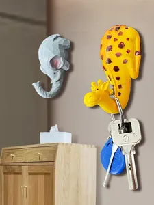 Detail of giraffe and elephant adhesive wall hooks for hanging keys in home entryway